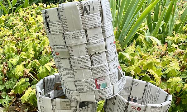 Grundschüler aus Vierreth-Trunstadt stellen Körbe aus gelesenen Zeitungen her.