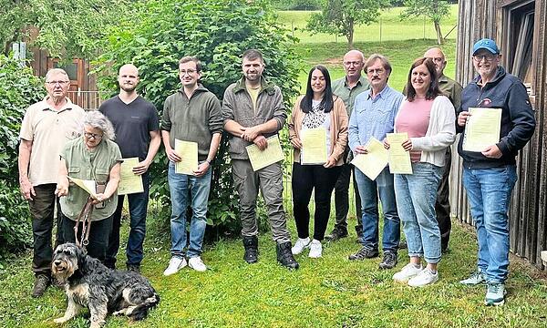 Die Halter der Jagd- wie auch Familienhunde nach der Prüfung mit ihren Urkunden.