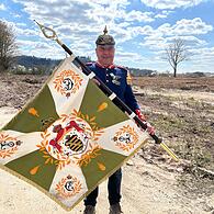 Besondere Erinnerung an Prinz Andreas: Mike Donner zeigt die besondere Fahne des Spielmannszugs der Freiwilligen Feuerwehr Eisfeld. Und die passende Uniform plus Pickelhaube trägt er gleich auch noch dazu.