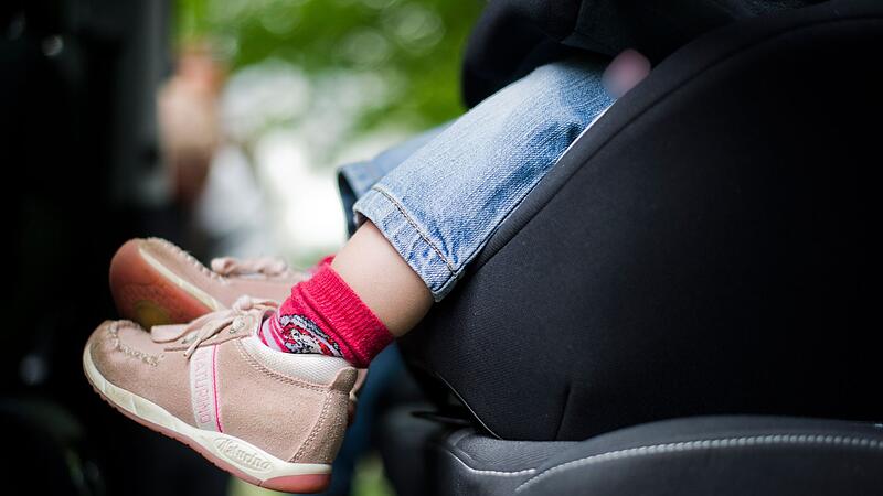 Mädchen sitzt in einem Kindersitz im Auto