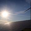 Windrad hinter Solarkraftanlage