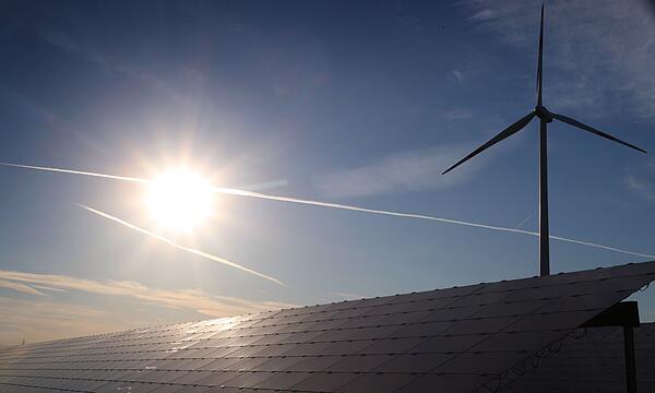 Windrad hinter Solarkraftanlage