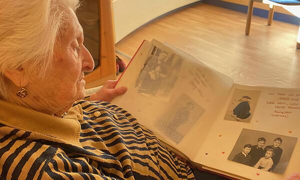 Christine Striegel aus Ebermannstadt blättert in einem Familienalbum.