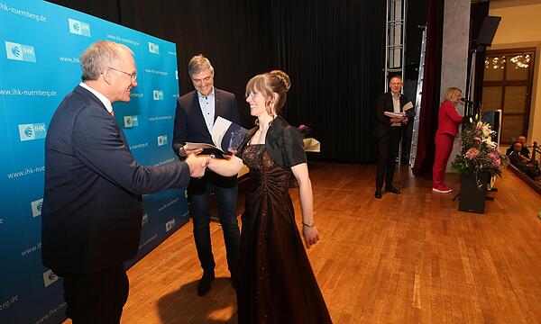 Martin Oberle (links) und Michael Thiem überreichen der   prüfungsbesten Elektronikerin, Svenja Jena, ihr Zeugnis.