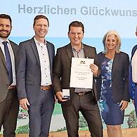 Die Ehrung des Preisträgers aus Oberfranken (v. l.): Christian Weber (Bürgermeister Stadt Pottenstein), Florian Wiedemann (Landrat Landkreis Bayreuth), Stefan Frühbeißer mit Lebensgefährtin Tina Angerer sowie Lothar Winkler (Leiter des Amtes für L...