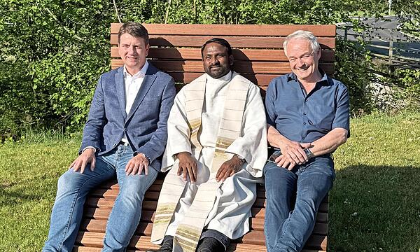 Sandro Kirchner (von links), Pater Thumma und Ortssprecher Eugen Edelmann testen die neue Sonnenliege.