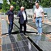 Landrat Thomas Bold (Mitte) schaut sich gemeinsam mit Andreas Fuchs und Mario Grom die frisch installierte Photovoltaik-Anlage an.