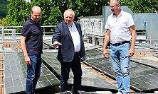 Landrat Thomas Bold (Mitte) schaut sich gemeinsam mit Andreas Fuchs und Mario Grom die frisch installierte Photovoltaik-Anlage an.