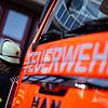 Feuerwehrmann steht neben einem Feuerwehrauto (Symbolbild)