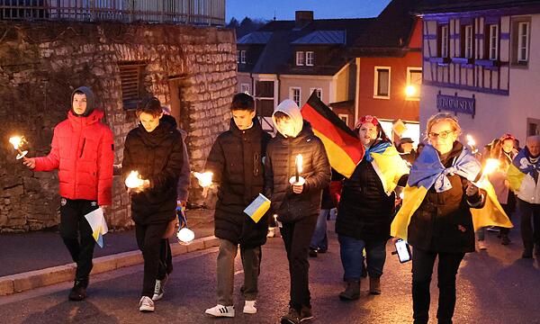 Mit Fackeln und Lampions zogen die Ukrainer mit einigen Helfern von der Villa -Zuflucht bis zum Marktplatz, um an den Jahrestag des russischen Überfalls auf die Ukraine zu erinnern.