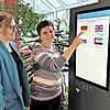 Lea Fuchs (links), Sachbearbeiterin Wohngeld und Bafög, und Tatjana Decker, Sachbearbeiterin Asyl, präsentieren das neue digitale Ticketsystem, das künftig im Amt für Soziales und Senioren für kürzere Wartezeiten sorgen soll.
