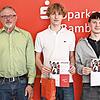 Vorstandsvorsitzender Stephan Kirchner (links) und Wertpapierbeauftragter David Förtsch (rechts) gratulieren Samuel Ziegelhöfer und Leon Motschenbacher vom Siegerteam „Gejagt vom Finanzamt“ vom Clavius-Gymnasium, zusammen mit ihrem Lehrer Jürgen S...
