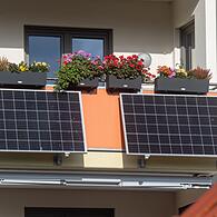 Solarmodule für ein Balkonkraftwerk hängen an einem Balkon