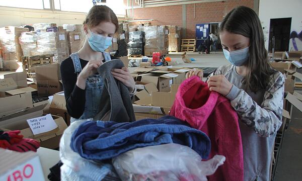 Lenja und Kim aus der 6f sortieren Kleidung für Geflüchtete aus der Ukraine.