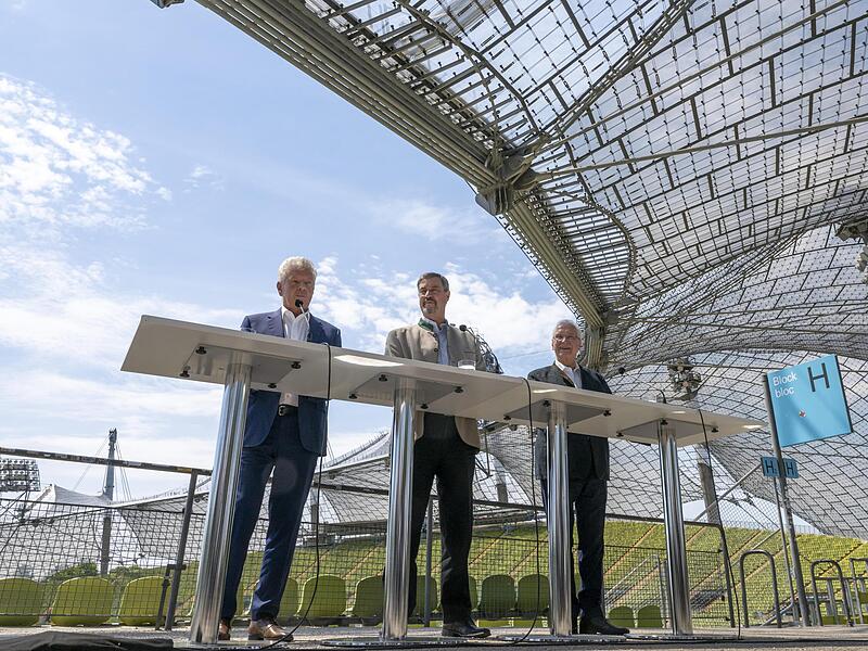 Münches OB Dieter Reiter (SPD), Ministerpräsident Markus Söder (CSU) und Innenminister Joachim Herrmann (CSU, von links) geben nach der Sitzung des Kabinetts im Olympiastadion bekannt: Die Stadt München will ihre Bürger für eine erneute Bewerbung ...