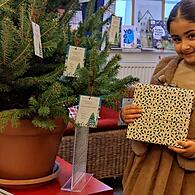 Sally freut sich, einen Weihnachtswunsch in der Buchhandlung Glückstein vom Baum nehmen zu können, um einem Kind eine Weihnachtsfreude bereiten zu dürfen.