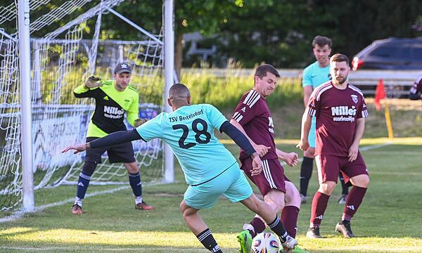 Patrick Williams (türkisgrün) vom TSV Bertelsdorf wird am Versuch, aufs Gauerstadter Tor zu schießen, gehindert.