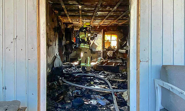 Eine Feuerwehr-Einsatzkraft steht in dem völlig ausgebrannten Wohnzimmer der Familie Pertsch in Untersiemau.