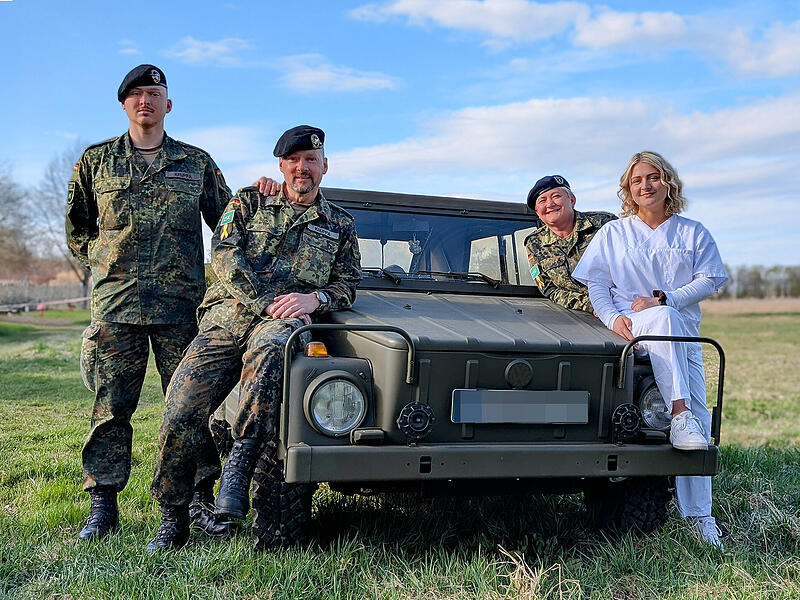 Die Familie Kruppa (von links): Sohn Justin, Vater Bernd, Mama Natalja und Tochter Leonie (vorne rechts) lehnen sich an einen alten Kurierwagen der Bundeswehr, den Vater Bernd restauriert hat.