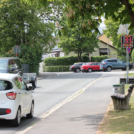 Geschwindigkeitsanzeigen sollen vor der Grundschule den Verkehr verlangsamen. Einige Autos bremsen ab, bis der Smiley grün lacht. Andere nicht.