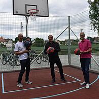 Christian Prophet, Bürgermeister Martin Walz und Martin Mehl probieren den neuen Basketballplatz in Neunkirchen am Brand aus.