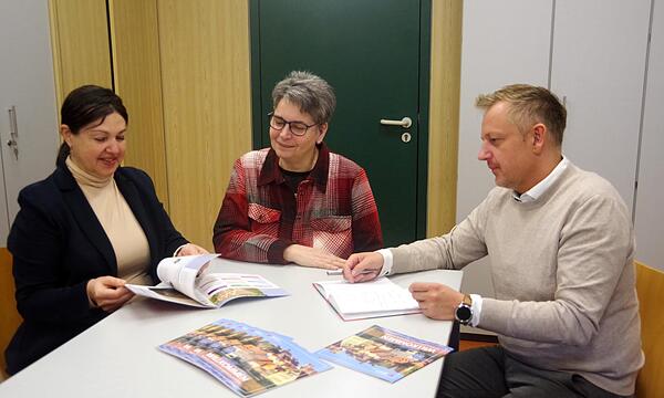 Bürgermeisterin Angela Hofmann, KoBE-Projektleiterin Sabine Nuber und Turnerschafts-Vorsitzender Jörg Schnappauf schmökern in der neuen Willkommens-Neubürgerbroschüre .