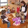 Im Waldorfkindergarten Wernstein schneiden Kinder mit Einrichtungsleiterin Elfriede Sauer Äpfel für einen Kuchen. Im Waldorfkindergarten Wernstein schneiden Kinder mit Einrichtungsleiterin Elfriede Sauer Äpfel für einen Kuchen.