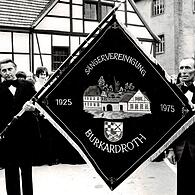 1975 wurde zum 50-jährigen Jubiläum eine neue Fahne angeschafft. Das Bild zeigt rechts Robert Schuldheis (heute noch Kassier im Verein), links daneben Ludwig Ehrenberg (damals erster Vorsitzender) und links ein Mitglied des Patenvereines aus Poppenroth.