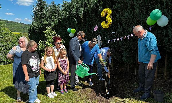 Die Flüchtlinge aus der Ukraine pflanzten  gemeinsam mit Susanne Werner und Alfons Hrubesch von der Opferhilfe sowie  Bürgermeister Roland Wolfrum ein neues Apfelbäumchen für den Frieden. Es ist schon das dritte.