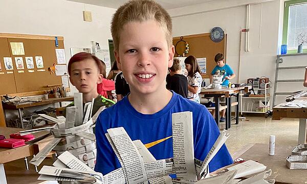 Grundschüler aus Vierreth-Trunstadt stellen Körbe aus gelesenen Zeitungen her.