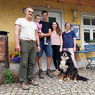 Beim Naturlandhof Weiß in Laibarös hat bereits die nächste Generation übernommen: Sohn Johannes (Mitte) mit Frau Sophia, eingerahmt von Otto und Irene Weiß und Hofhund Maja.