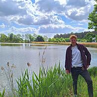 Louis Grimmer vor einem der Fischteiche in Trabelsdorf. Im Hintergrund sieht man das Restaurant und Hotel „Altes Kurhaus“.