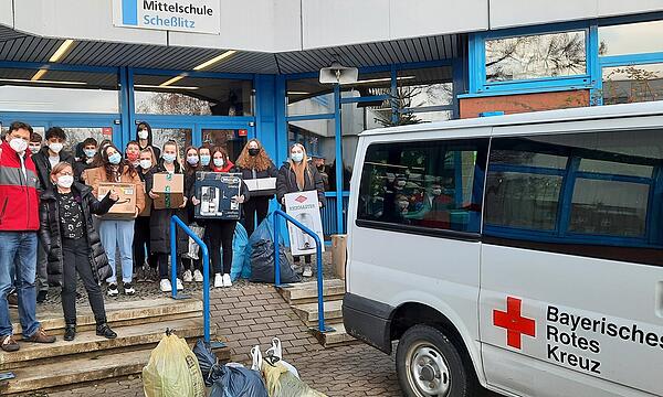 Mitarbeiter der Kleiderkammer des Bayerischen Roten Kreuzes und des Vereins "Freund statt fremd" freuen sich über die Kleiderspenden der Mittelschule Scheßlitz.