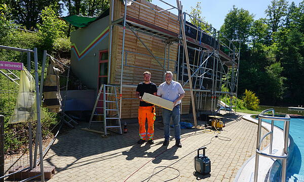 Bürgermeister Marc Benker und Badleiter Rene Klatt kürzlich beim Technikgebäude, an dem die Bauarbeiten jetzt abgeschlossen sind. Sie hoffen auf schönes Wetter und viele Besucher.