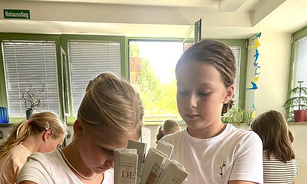 Grundschüler aus Vierreth-Trunstadt stellen Körbe aus gelesenen Zeitungen her.