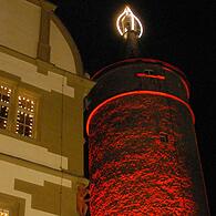 Die größte Adventskerze Bayerns leuchtet seit Freitagabend wieder in Kitzingen mit dem rot illuminierten Stadtturm.